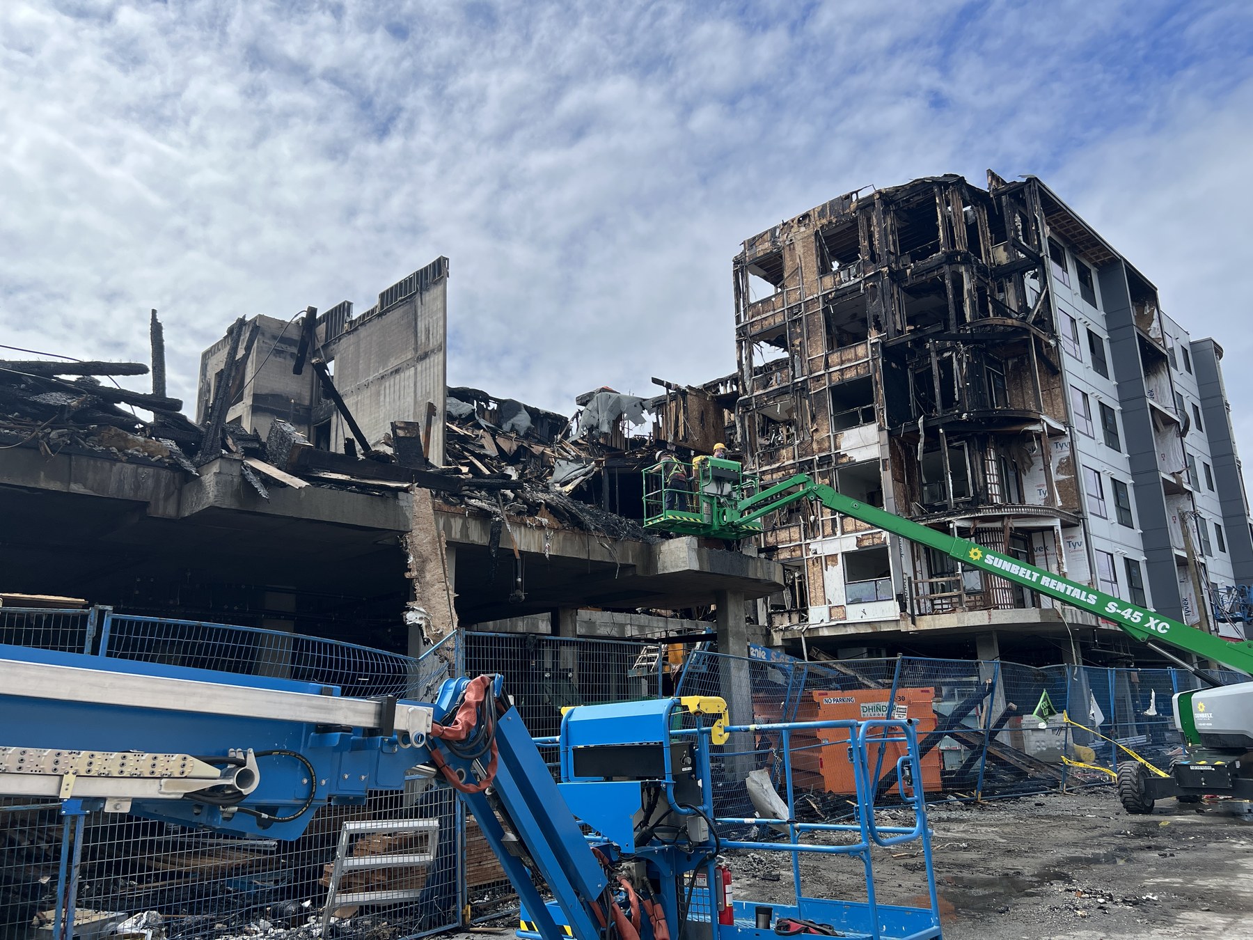 Wide view of Langley construction fire damage with lift equipment and structural debris
