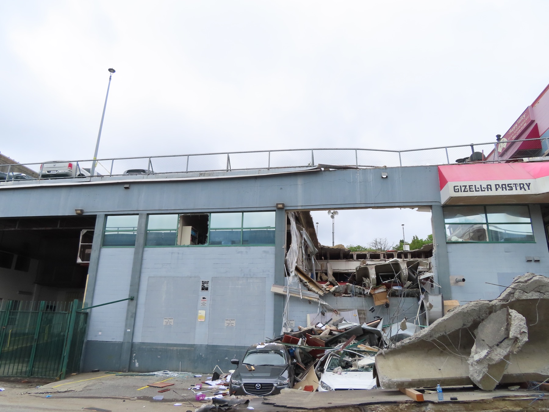 Collapsed rooftop parkade and damaged commercial building on Lougheed Highway