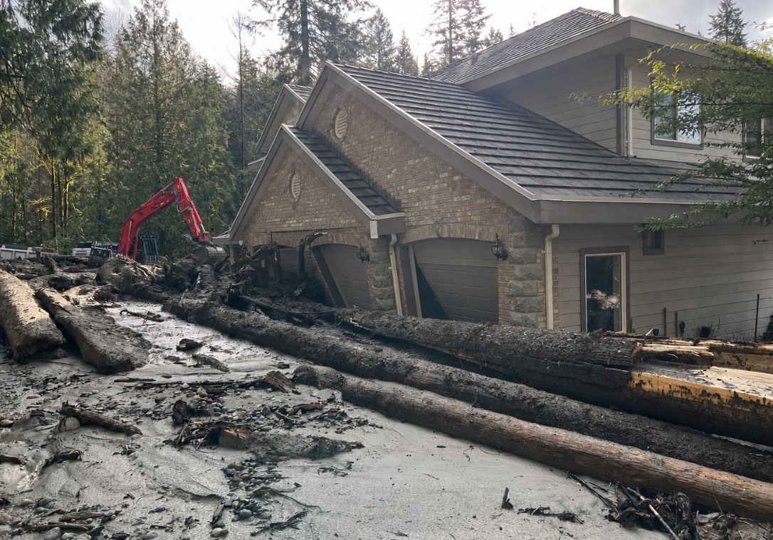 Water and debris damage around a residential garage and driveway