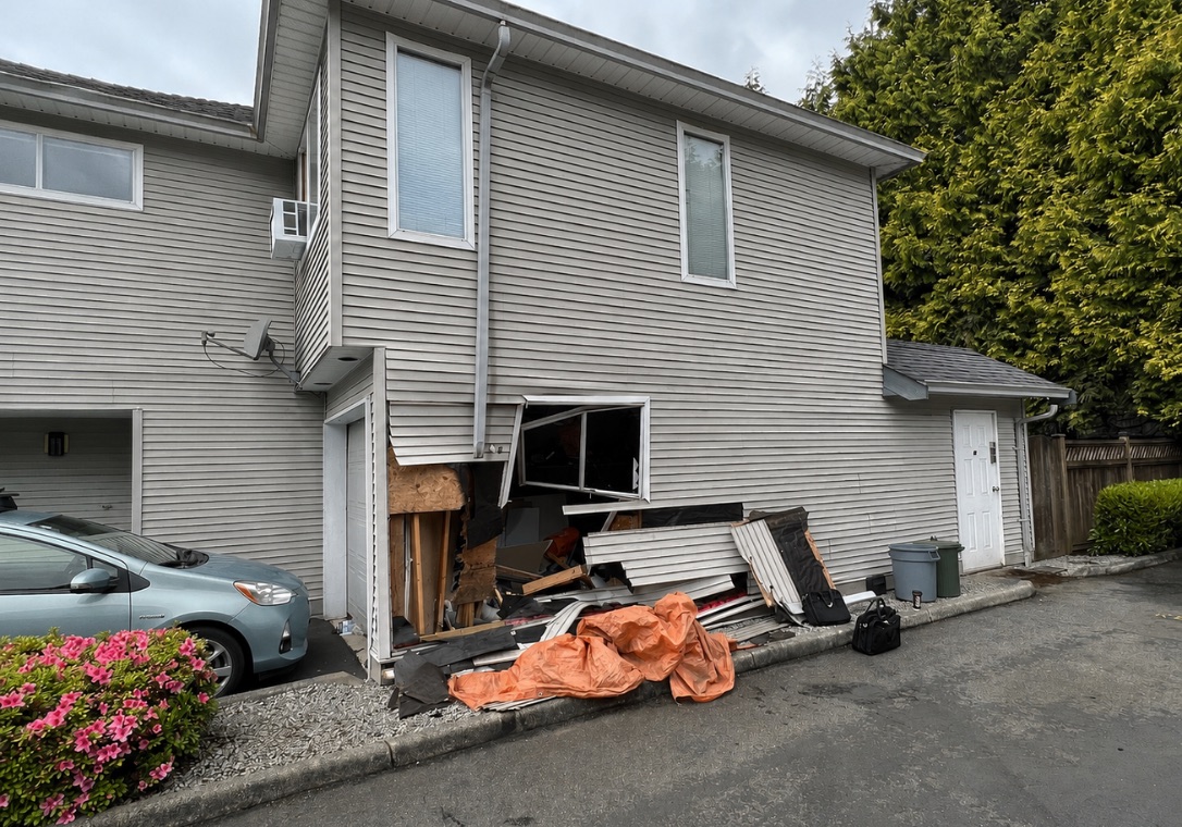 Exterior wall and siding damage from a vehicle impact at a residential building