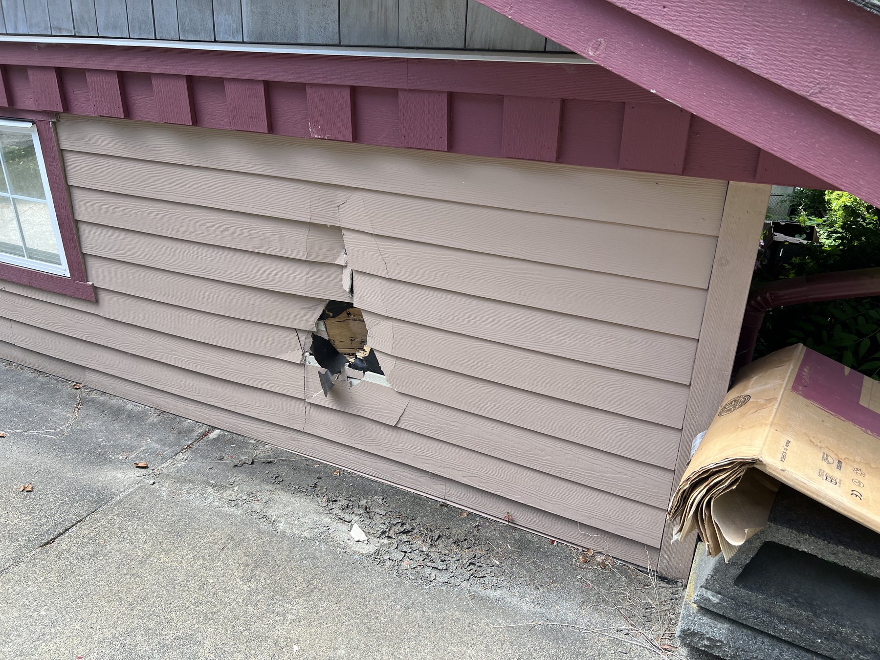 Exterior siding and wall damage from a vehicle impact